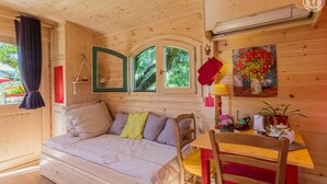 Un acogedor interior de cabaña con una cama, una mesa de comedor y una silla.
