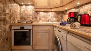 A compact kitchen with a Bosch dishwasher, a washing machine, a coffee maker, and a sink. - L'eglantier - Meribel-les-allues (MERIBEL LES ALLUES)