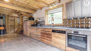 Eine moderne Küche mit Holzausstattung, einem Bosch-Ofen und einem eingebauten Geschirrspüler.