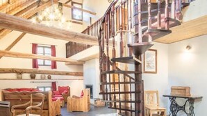 A spacious loft with a wooden staircase, a fireplace, and a cozy seating area. - Chez LE Marquis DU Pontet 5 (VALLOIRE)