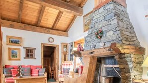 A rustic interior with a stone fireplace, wooden beams, and a cozy seating area. - Chalet Bellacomba-grd Paradis (SAINTE FOY TARENTAISE)