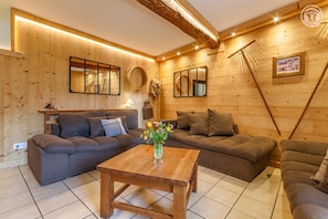 Un interior acogedor de madera con un sofá, una mesa de centro de madera y un espejo.