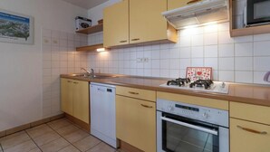 Eine Küche mit Geschirrspüler, Herd, Backofen und Mikrowelle.
