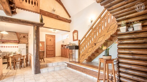 A rustic interior with a wooden staircase, a dining area, and a kitchen. - LA Grange - Traize - Gîte (TRAIZE)
