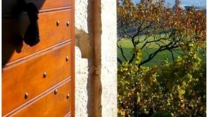 A wooden door with metal studs, leading to a view of a church steeple and autumn foliage. - LA Grange - Traize - Gîte (TRAIZE)