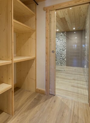 A wooden interior with a sliding glass door leading to a bathroom with patterned tiles. - LE Petit Chalet - LA Rosiere-montvalezan (LA ROSIERE MONTVALEZAN)
