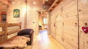 Un interior de madera con un largo pasillo, una mesa de madera y una silla.