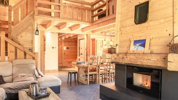 Un interior espacioso de madera con chimenea, un sofá y un comedor.
