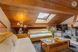 Ein gemütliches Loft-Wohnzimmer mit Holzboden, einer Couch, einem Couchtisch und einem Kamin.