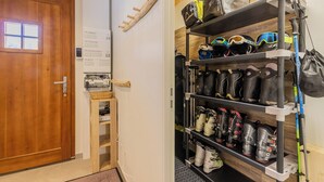 A wooden door, a wall-mounted electrical panel, and a rack with ski boots and gear. - LE Davo - Hauteluce - Gîte (HAUTELUCE)