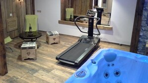 A home gym with a treadmill, exercise equipment, and a hot tub. - Chalet LES Ancolies - Valloire (VALLOIRE)