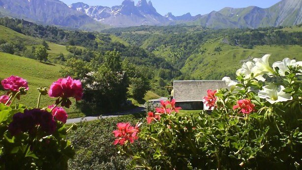 A mountainous landscape with a building in the foreground.
