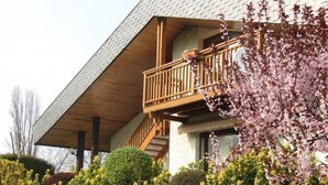 Een gebouw met twee verdiepingen, een houten balkon en een overdekte veranda.