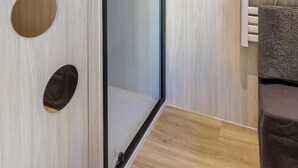 Une salle de bain moderne avec un mur en bois, une cabine de douche en verre et un porte-serviettes.
