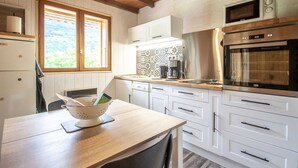 A modern kitchen with white cabinetry, a wooden countertop, and a built-in oven.