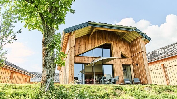 Un edificio moderno de madera con techo inclinado y ventanas grandes.