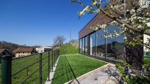 A modern building with large glass windows, a grassy lawn, and a metal fence. - L'arveysan - Ste-marie-d'alvey (SAINTE MARIE D'ALVEY)