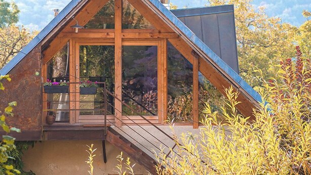 A wooden cabin with a sloped roof, large windows, and a balcony with potted plants. - UN Loft A LA Campagne (SAINT JEAN D'ARVEY)