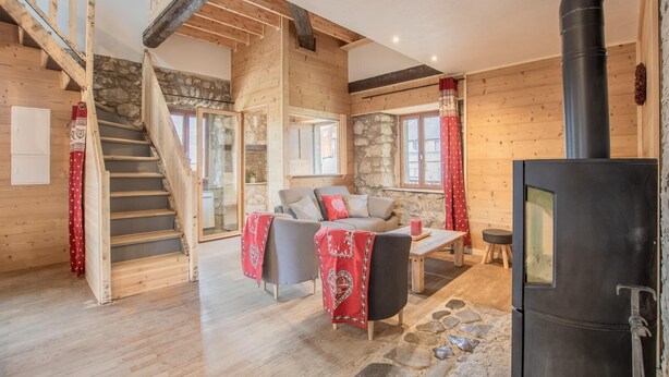 A cozy cabin with a wooden interior, a stone wall, a fireplace, and a staircase. - LES Luzes - Lescheraines (LESCHERAINES)