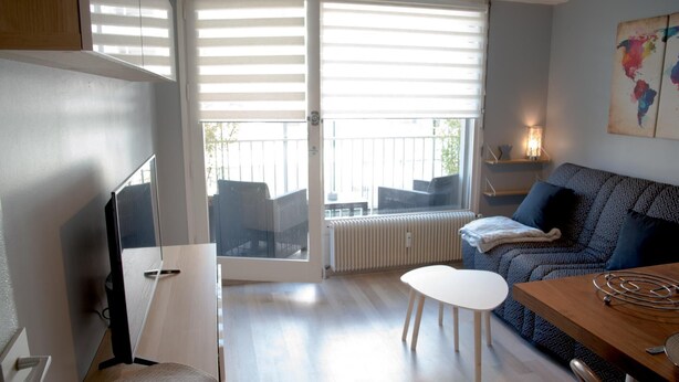 Ein modernes Wohnzimmer mit Sofa, Couchtisch und Fernseher.