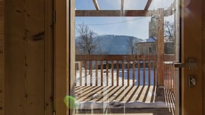 A wooden door leading to a balcony with a view of a snowy landscape and mountains. - Gites DE Beaune - LE Brequin (SAINT MICHEL DE MAURIENNE)