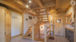 A wooden interior with a staircase, wooden doors, and a tiled floor. - Chalet L'escampette - Hauteluce-les-saisies (HAUTELUCE-LES-SAISIES)