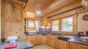 A wooden cabin kitchen with granite countertops, wooden cabinets, a dishwasher, and a sink. - Chalet L'escampette - Hauteluce-les-saisies (HAUTELUCE-LES-SAISIES)
