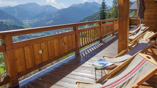 A wooden deck with lounge chairs and a view of mountains. - Chalet L'escampette - Hauteluce-les-saisies (HAUTELUCE-LES-SAISIES)