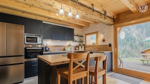 Una cocina moderna con armarios de madera, electrodomésticos de acero inoxidable y una isla grande con taburetes de bar.