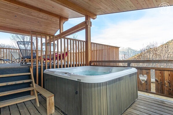 A wooden deck with a hot tub, wooden railings, and a view of mountains. - L'ecoliere - Valmeinier (VALMEINIER)