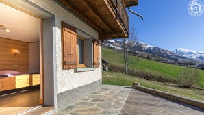 Une façade en bois avec des marches en pierre menant à une chambre à coucher équipée d’un lit et d’une table de chevet.