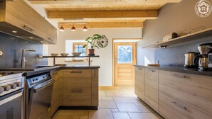 Une cuisine moderne avec des meubles en bois, un îlot central et des appareils électroménagers en acier inoxydable.