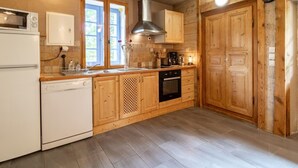 Una cocina con armarios de madera, un refrigerador blanco, una estufa y un microondas.