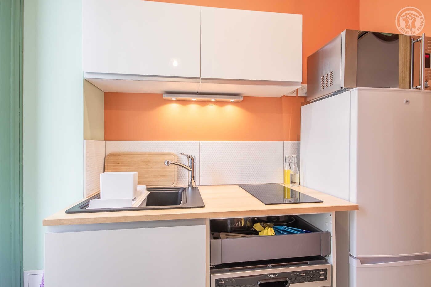 A compact kitchen with a built-in oven, a sink, and a countertop.