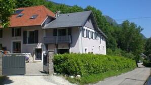 A two-story house with a red-tiled roof, a balcony, and a stone wall. - LES Cachouds - LE Bourget-du-lac (LE BOURGET DU LAC)