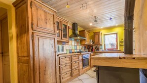 Une cuisine avec des meubles de rangement en bois, une cuisinière et un évier.