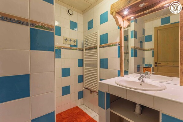 A bathroom with blue and white tiles, a white sink, and a wooden door.