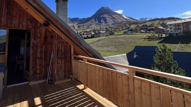 A wooden deck with a view of a mountain and a village. - LA Ferme DU Soleil - Combles (ALBIEZ MONTROND)
