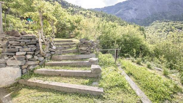 A stone staircase leading up a hillside with a view of a forested valley and mountains in the background. - LA Tour - St-martin-d'arc (ST-MARTIN-D'ARC)