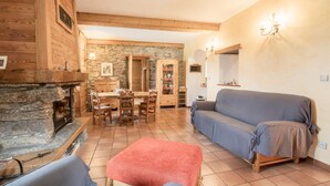 A cozy living room with a stone fireplace, wooden furniture, and a blue sofa. - LA Tour - St-martin-d'arc (ST-MARTIN-D'ARC)