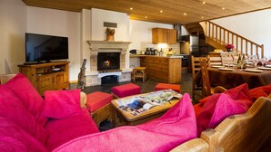 A cozy living room with a fireplace, wooden furniture, and a dining area set for a meal. - Chez LE Marquis DU Pontet 4 (VALLOIRE)