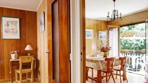 Una habitación con piso de madera, un comedor y un balcón.