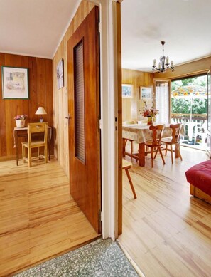A wooden-floored room with a dining area and a balcony. - LA Bonne EAU N°1 - Valloire (VALLOIRE)