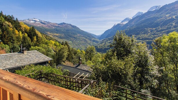 Vistas panorámicas de la montaña con una terraza de madera que da a un valle.