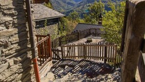 Un edificio de piedra con un balcón de madera que da a un paisaje montañoso.