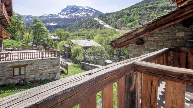 A rustic wooden balcony overlooking a mountainous landscape with traditional stone buildings. - LA Pastourelle 2 - Bonneval SUR ARC (BONNEVAL SUR ARC)