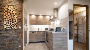 Eine moderne Küche mit Holzausstattung, einer Steinwand und einem eingebauten Herd.