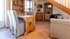 A cozy living room with a dining area, wooden furniture, and a staircase. - Merlin - Ste-helene-du-lac (SAINTE HELENE DU LAC)