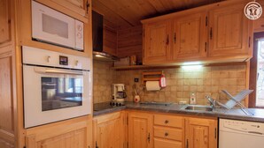 Una cocina con armarios de madera, estufa, microondas y lavavajillas.