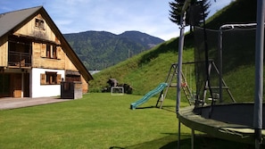Escape to a serene mountain retreat with a lawn, slide, and trampoline.